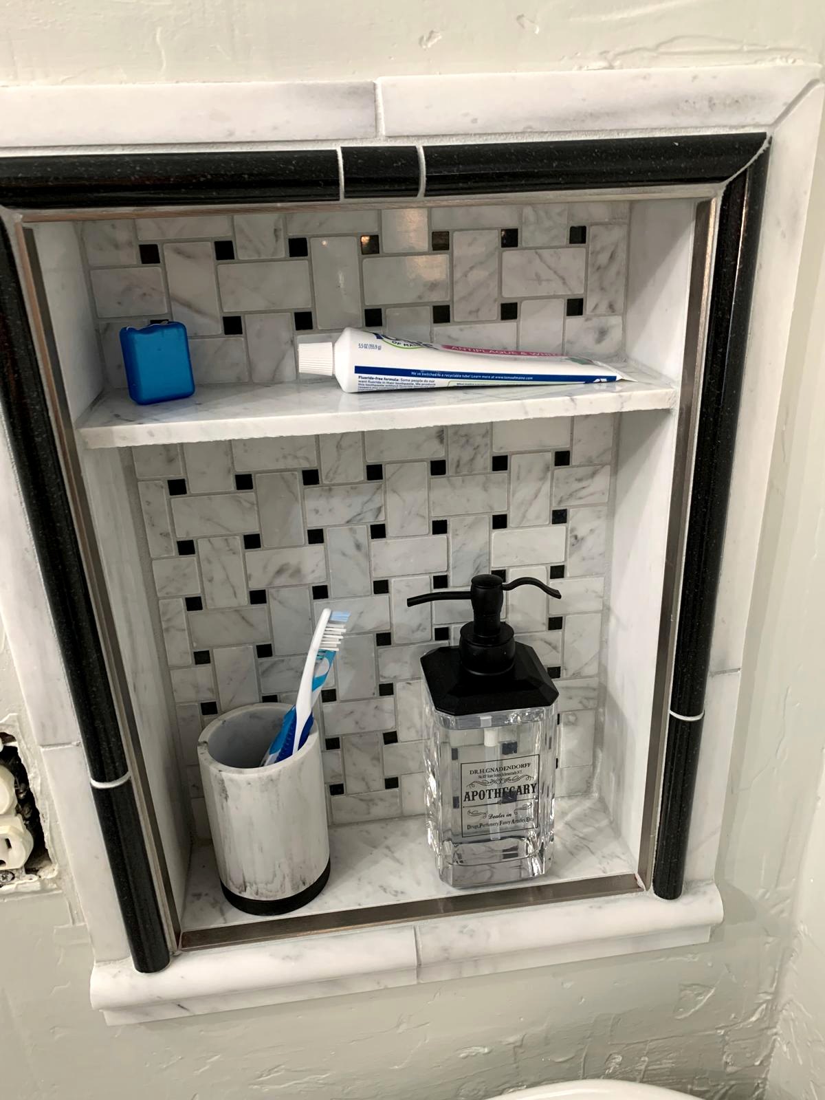 Open marble mosaic storage niche created where an unstable medicine cabinet had been removed