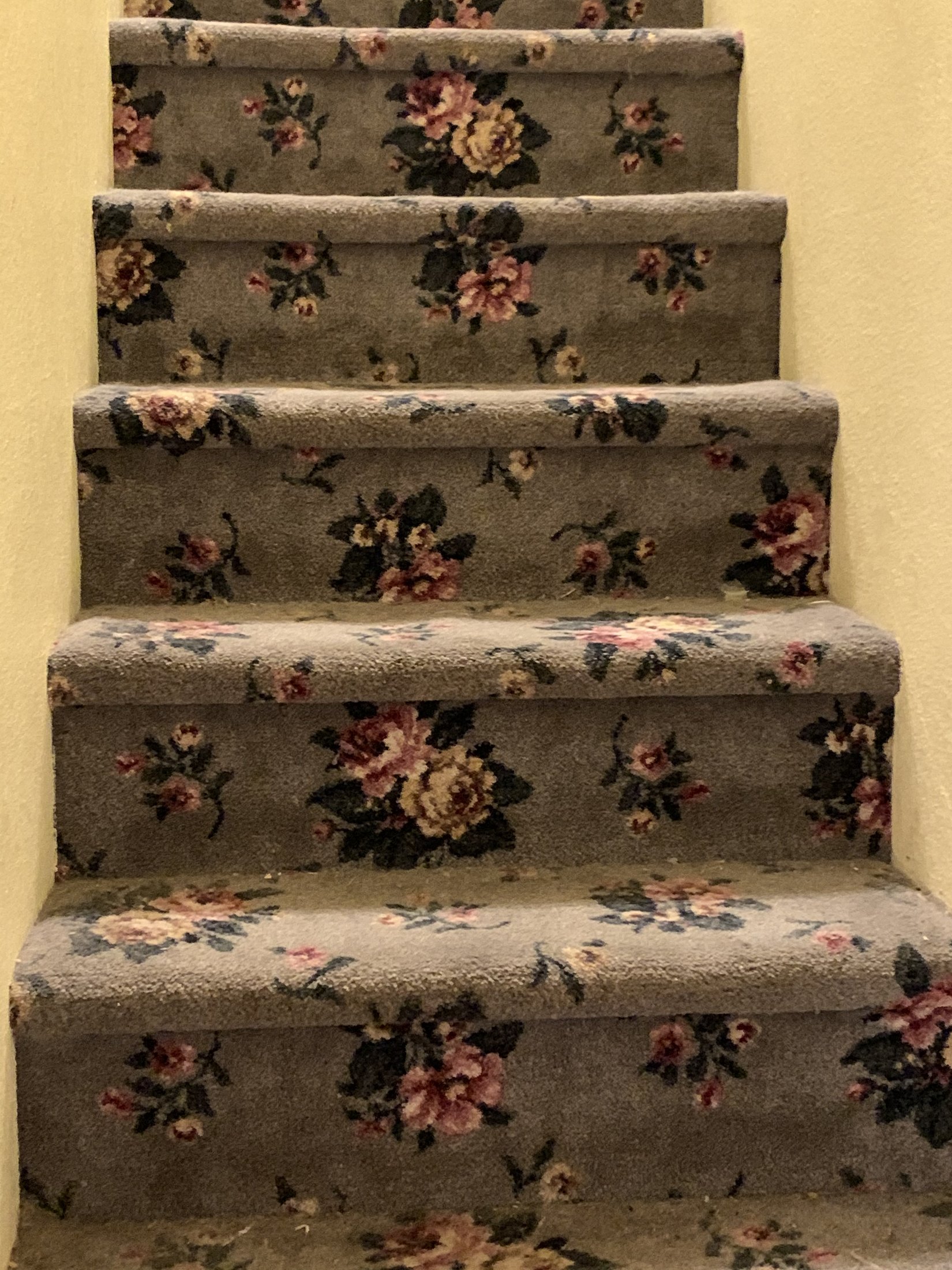 Stair to the attic before renovation with green floral carpet