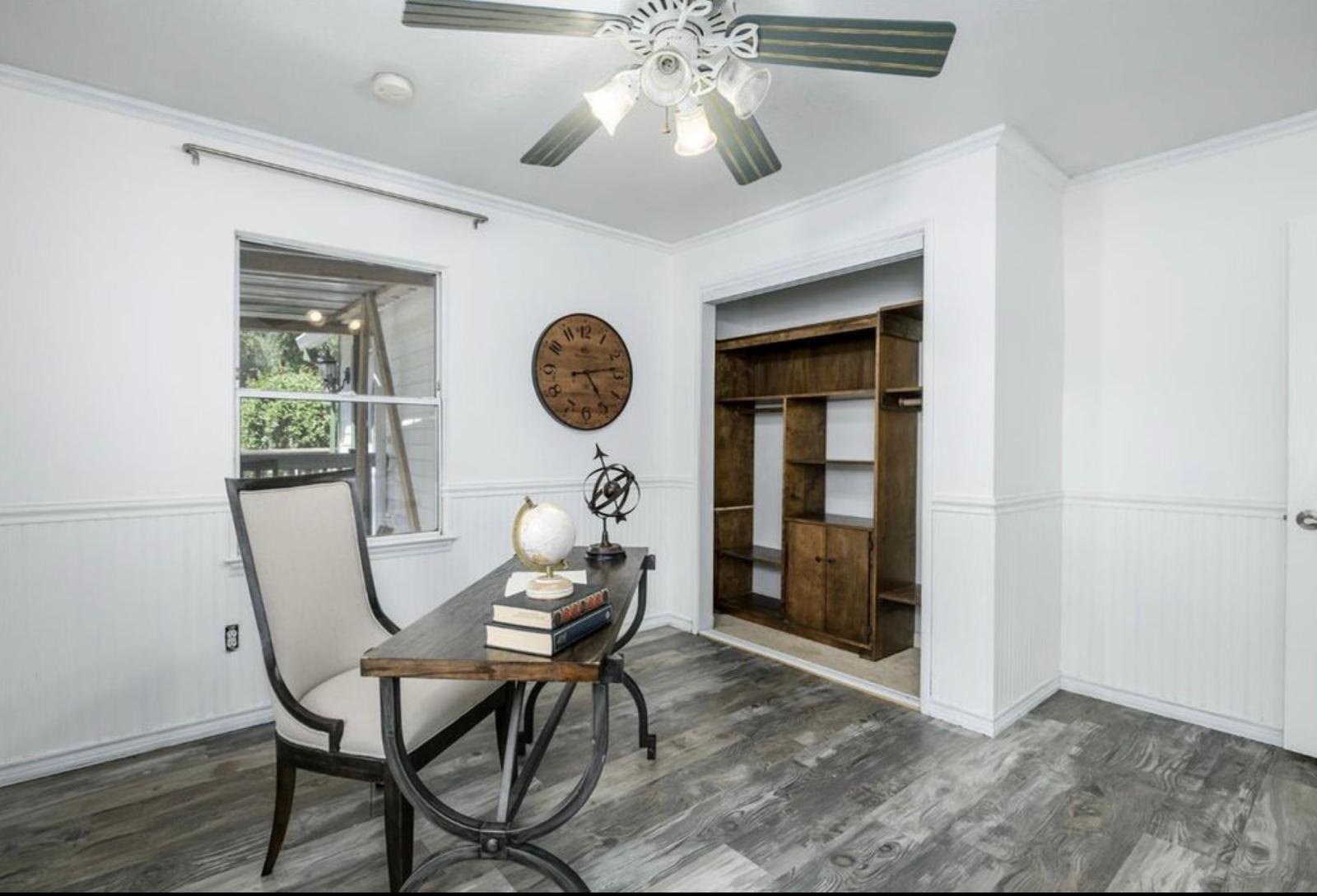 Former daughter’s bedroom with paneled walls, built-in closet storage, and a desk