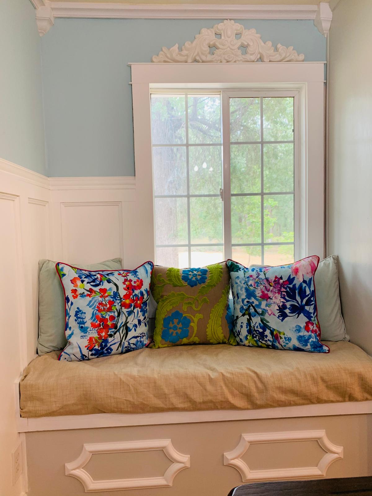 Built-in farmhouse window seat layered with colorful Designers Guild pillows