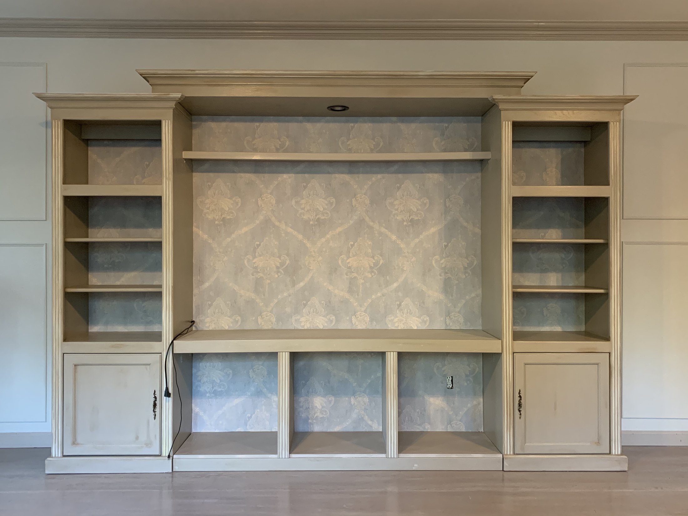 Entertainment center painted and altered to read as a built-in within the paneled room