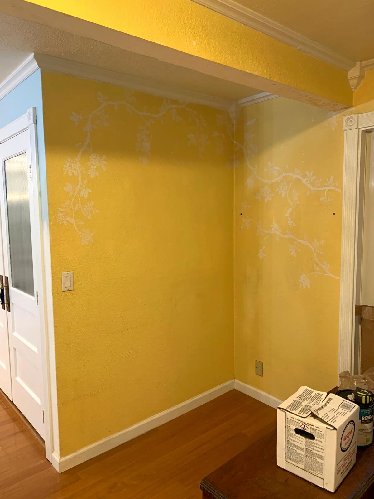 Empty yellow entry corner before the wall paneling and sitting area were added