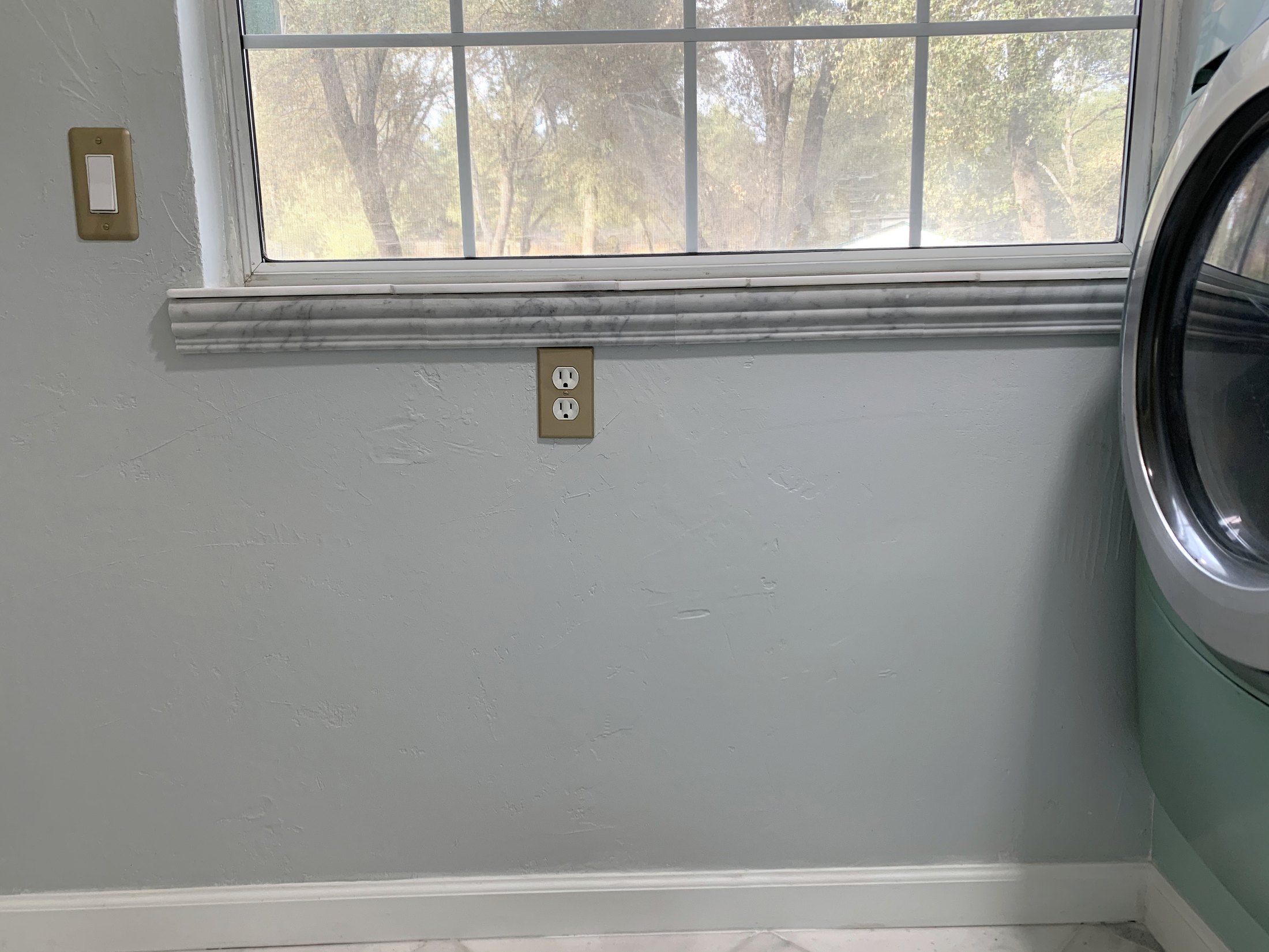 Finished laundry window with marble sill and detailed trim