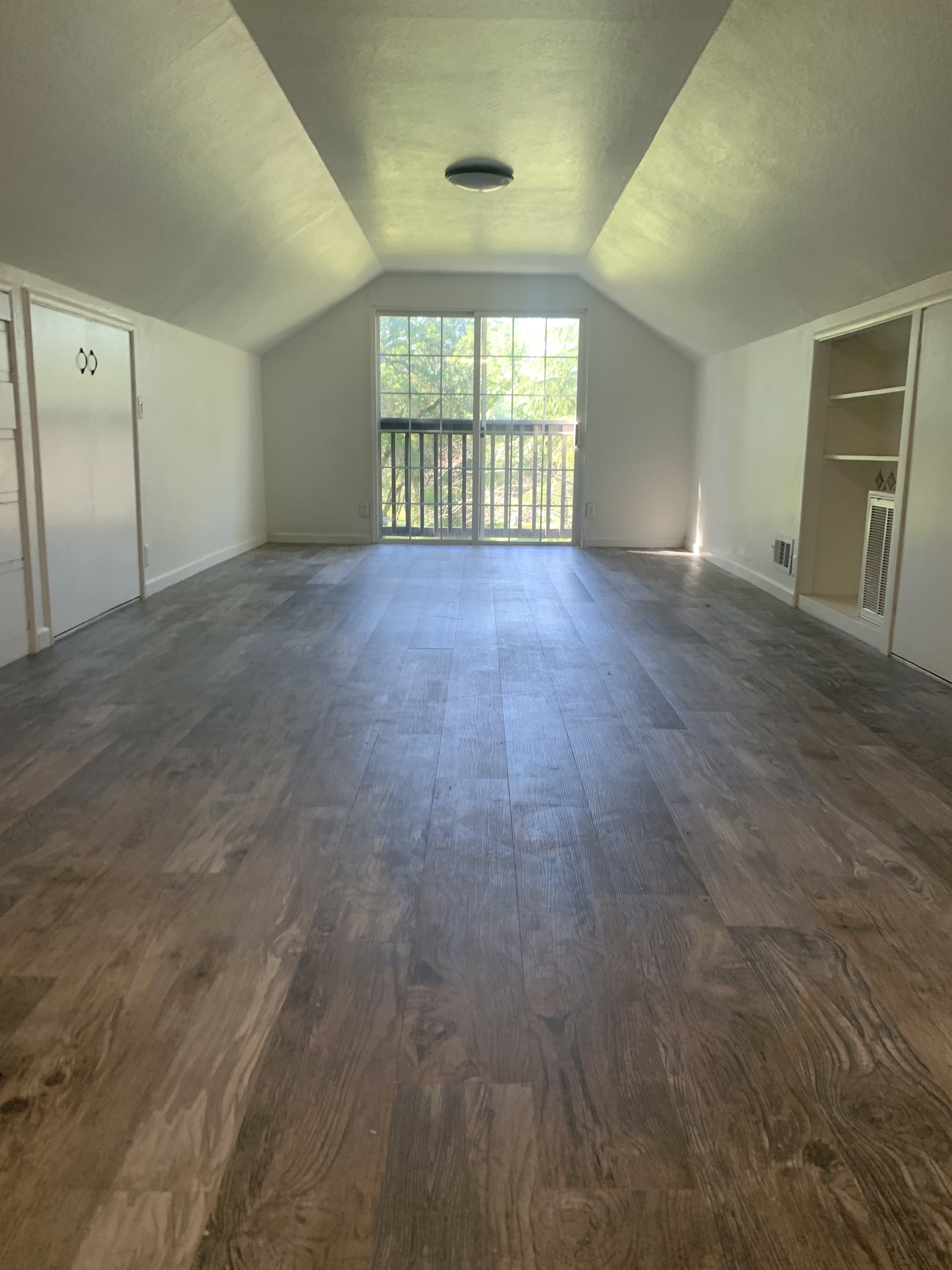 Converted attic bedroom before furnishing, showing the long room and sloped ceiling