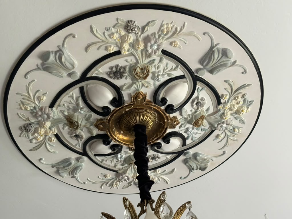 Close view of the floral ceiling medallion painted by hand to complement the restored chandelier