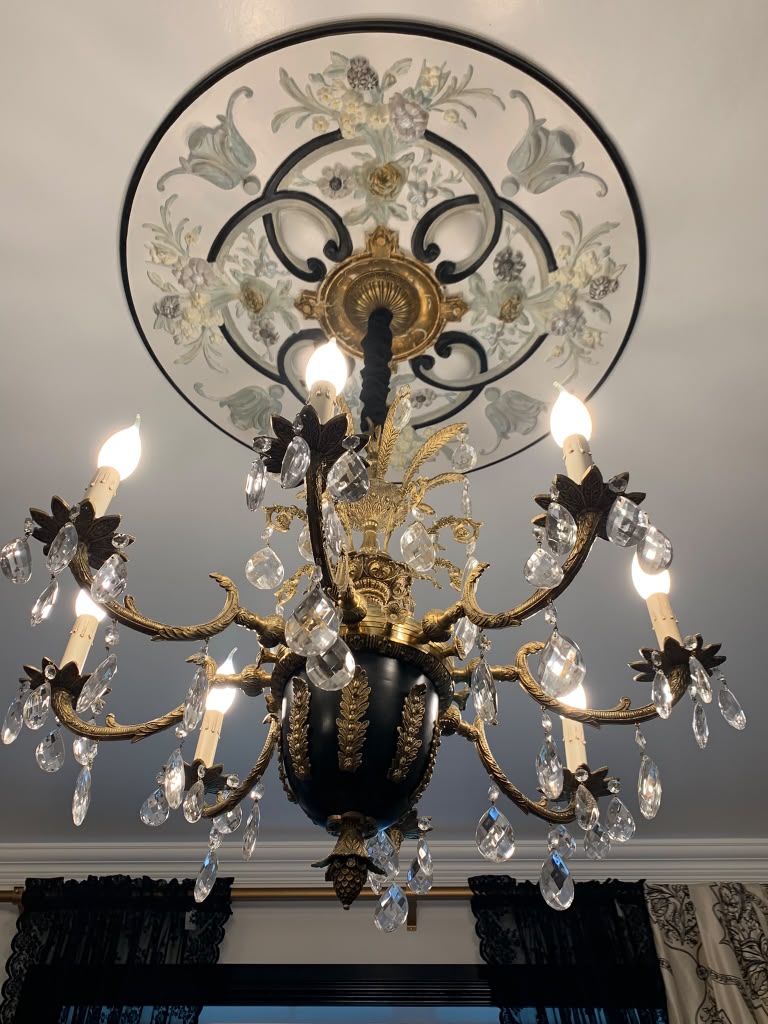 Restored antique chandelier beneath a hand-painted ceiling medallion