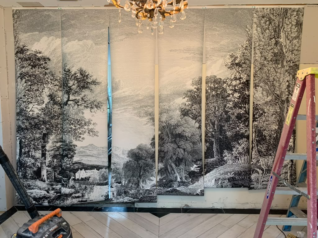 Scenic mural panels being installed around the dining room